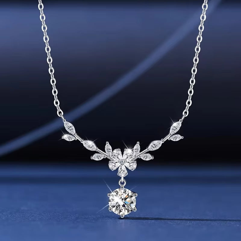 Silver necklace with a floral pendant on a dark blue background