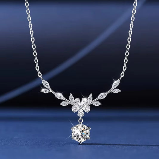 Silver necklace with a floral pendant on a dark blue background